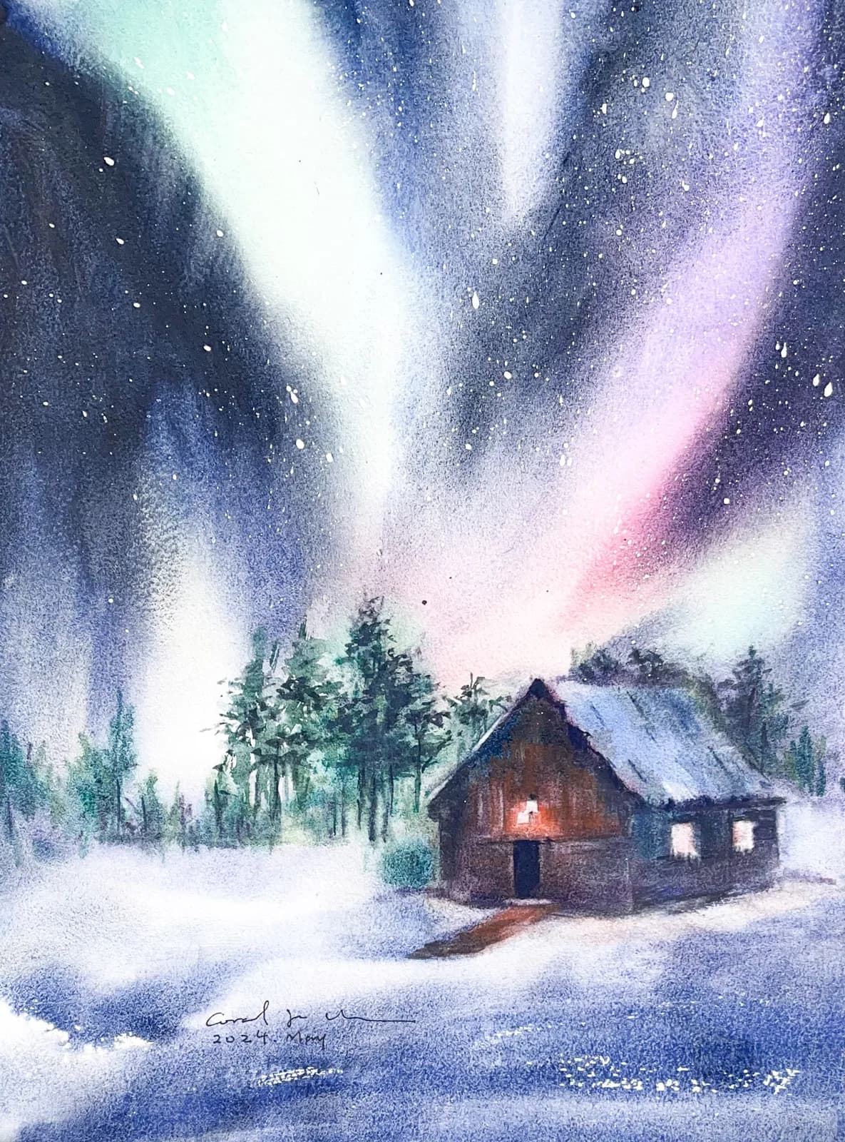 Watercolour of the northern lights in green, violet and pink over a snowy cabin with glowing windows and dark pines.